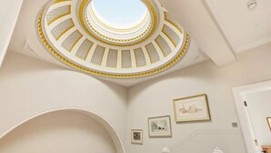 Eine imposante Treppe mit einem runden Oberlicht und einem hölzernen Geländer.