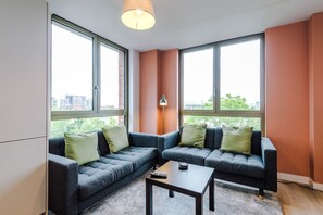 Ein modernes Wohnzimmer mit einem Ecksofa, einem Couchtisch und einer Stehlampe.