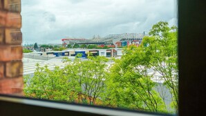 Een uitzicht op een stadion met een grote dakconstructie, omringd door gebouwen en groen.