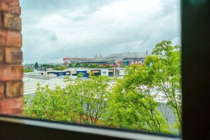 A view of a stadium with a large roof structure, surrounded by buildings and greenery. - 2BDR Old Trafford Free Parking Rooftop Terrace (Stretford)