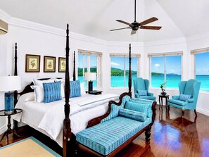A four-poster bed with a canopy, a ceiling fan, and a view of the sea. - Oceanfront Paradise staffed 4 bedroom Home Views Pool Beach Access Gym Tennis (Montego Bay)