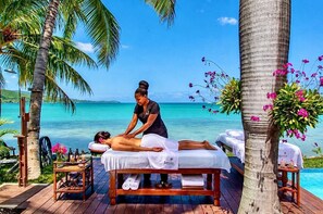 Eine Massage auf einer Holzterrasse mit Blick auf das Meer.