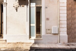 A building entrance with a door, a mailbox, and a number sign. - Cori miu Home - One Bedroom Apartment, Sleeps 2 (Avola)