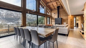 Un interior modern amb zona de menjador, sofà i llar de foc.