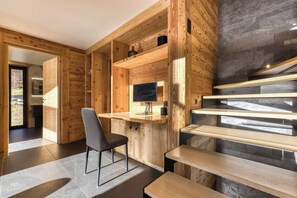 Ein modernes Interieur mit Holzwänden, einem Schreibtisch, einem Stuhl und einer Treppe.