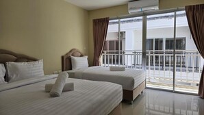 A hotel room with two beds, a balcony, and an air conditioning unit. - Blue Sapphire Hotel (Patong)