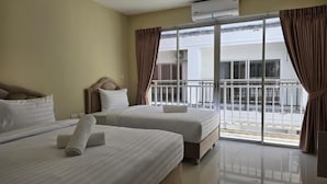 A hotel room with two beds, a balcony, and an air conditioning unit. - Blue Sapphire Hotel (Patong)