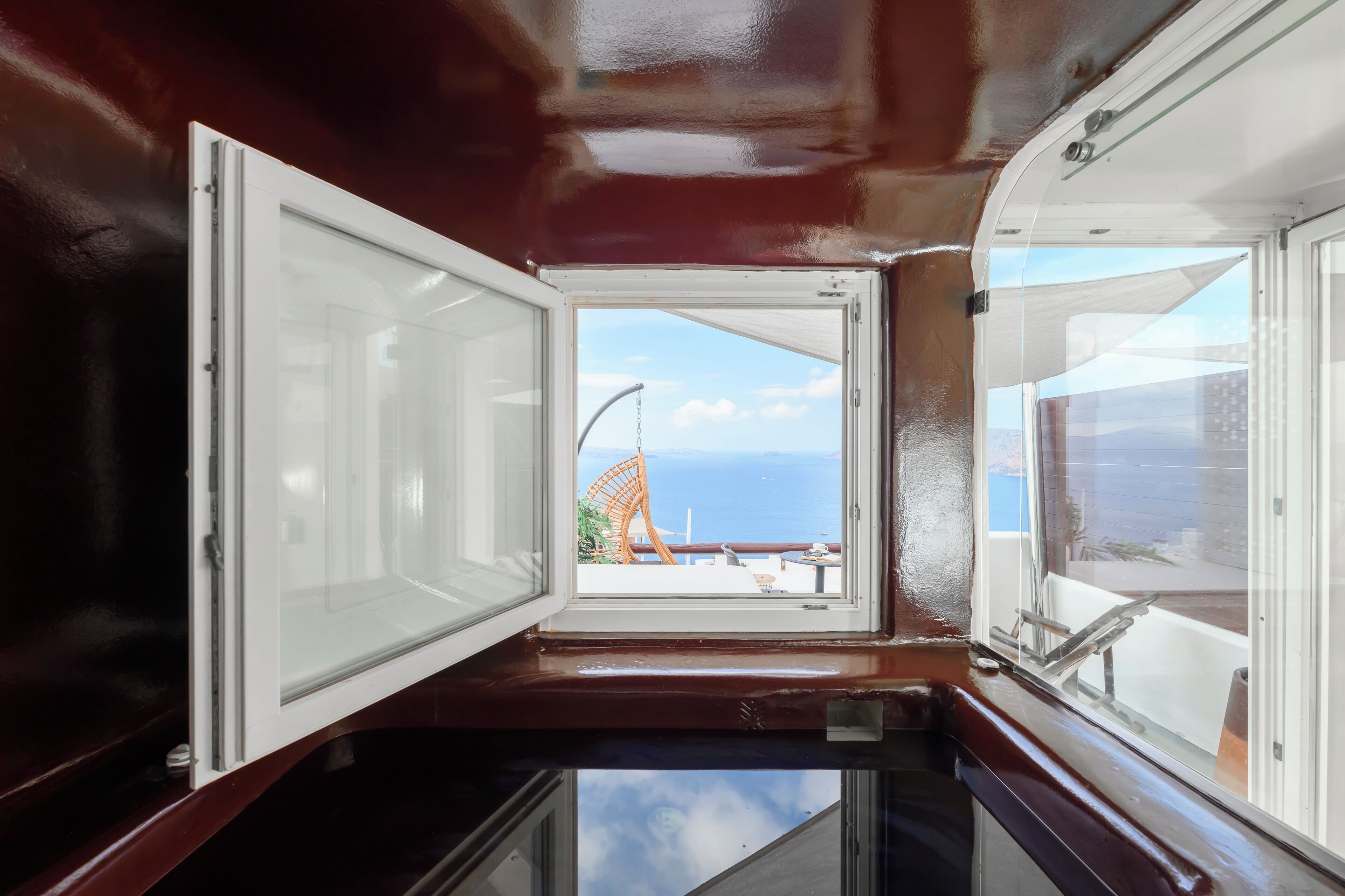 Ein Zimmer mit großem Fenster, Meerblick und Balkon mit einem Stuhl.