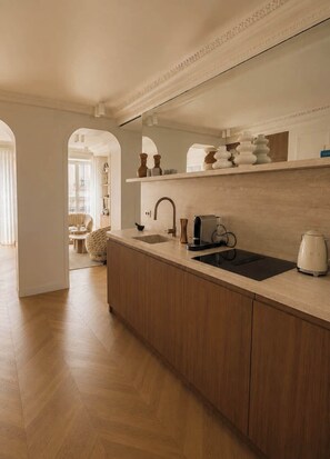 Une cuisine moderne avec des meubles en bois, un évier et une machine à café.