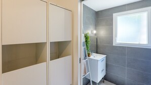 A bathroom with a shower, a window, and a white cabinet. - Holiday Home 'Le Gecko' with Private Terrace and Wi-Fi (Saint-Germain)