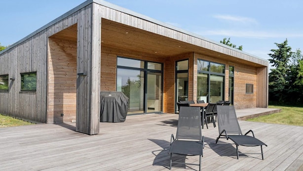 A modern house with a deck, large windows, and outdoor furniture. - 4 Star Holiday Home in Allinge (Allinge)