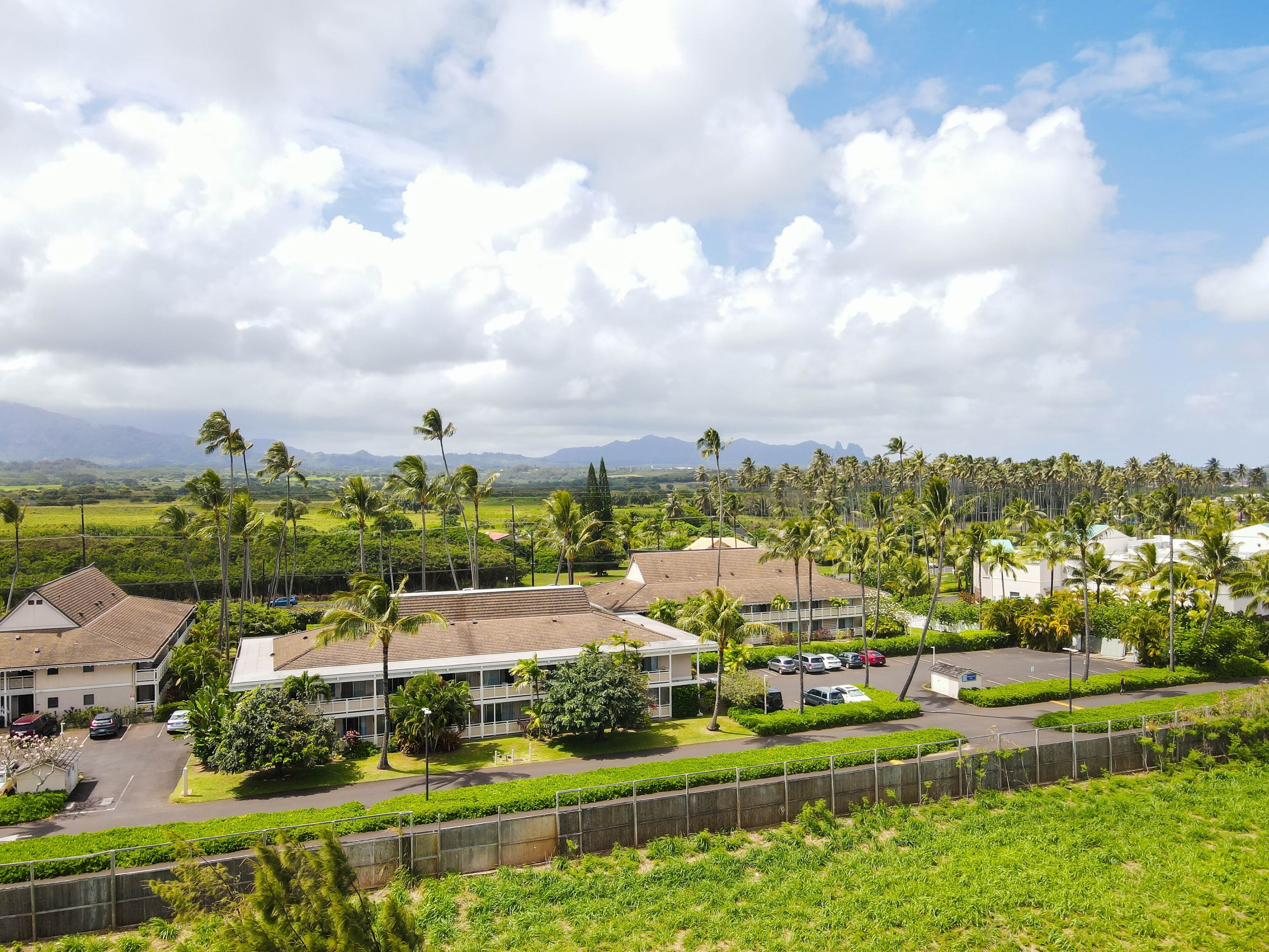 A residential area with houses, a parking lot, and a view of mountains in the distance.