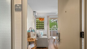 Et hotelværelse med sofa, en fletstol, et lille bord og et vindue med udsigt.