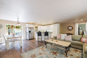 A spacious living area with a dining table, a sofa, and a kitchen in the background. - Stella 3 Bedroom Home (Bend)
