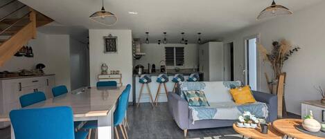 Un interior moderno con comedor, sofá y cocina.