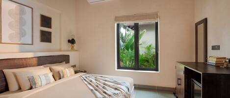 Une chambre à coucher comprenant un lit, une table de chevet, une commode et une fenêtre donnant sur un paysage verdoyant.