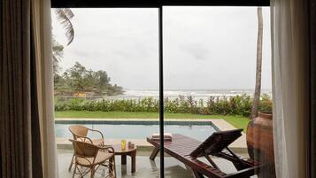Ein Zimmer mit Meerblick, einem Pool und Gartenmöbeln.