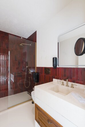A bathroom with a shower, a sink, a mirror, and a soap dispenser. - YU Townhouse (Bodrum)