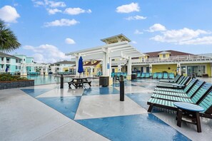 Ein Poolbereich mit Liegestühlen, einer überdachten Sitzgelegenheit und einem Pool.