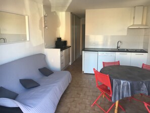 A compact living space with a kitchenette, a dining area with a table and chairs, and a sofa with cushions. - LA FRANQUI 6 people, Pets (LA FRANQUI)
