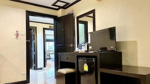 Una kitchenette compacta con refrigerador, microondas y una pequeña encimera.