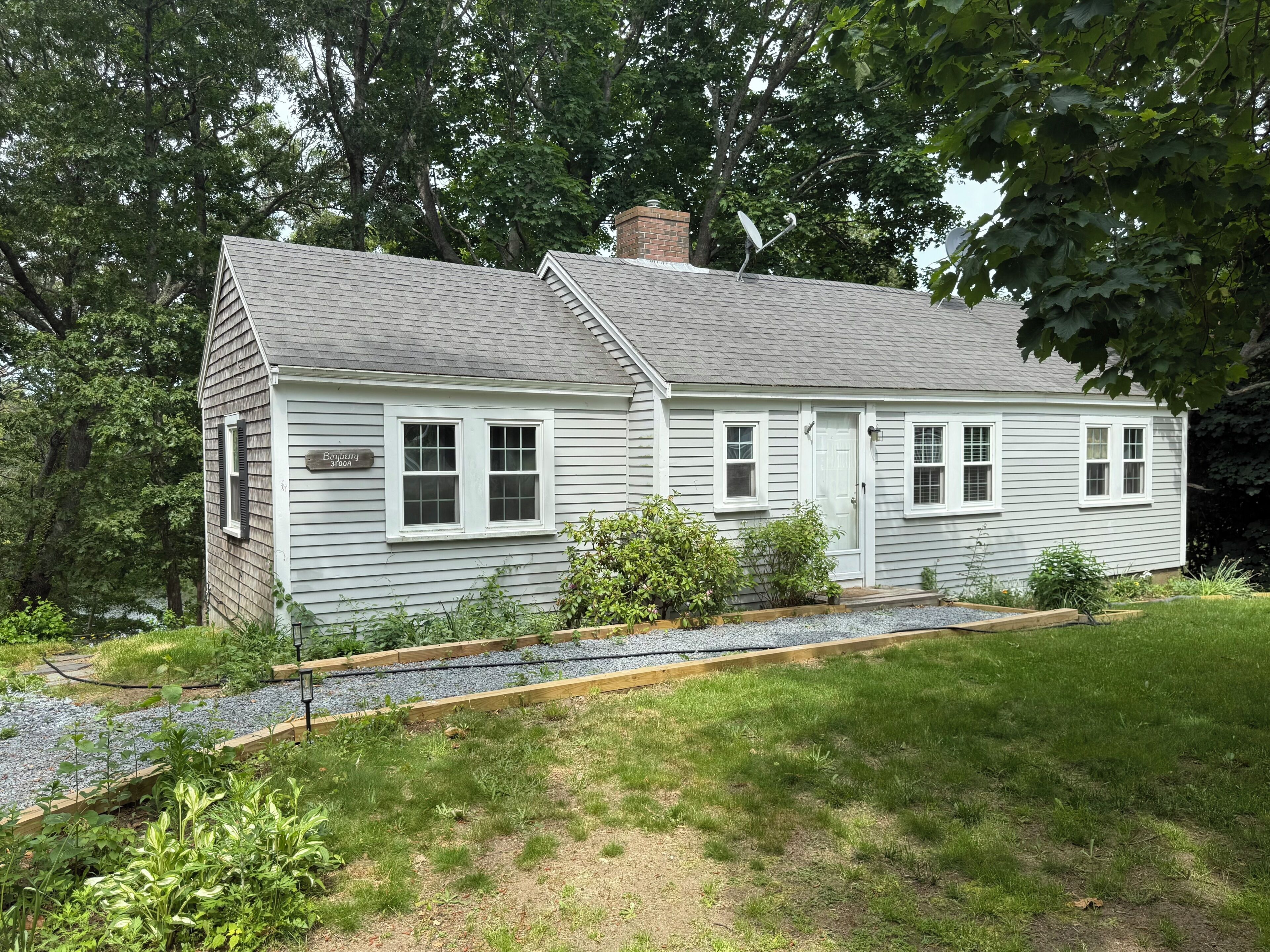 A two-story house with a chimney, a front door, and a small porch area.