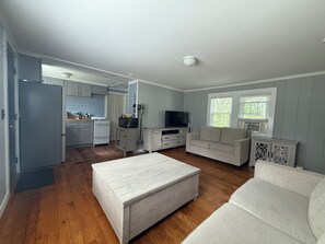 A compact living space with a kitchenette, a sofa, and a television.