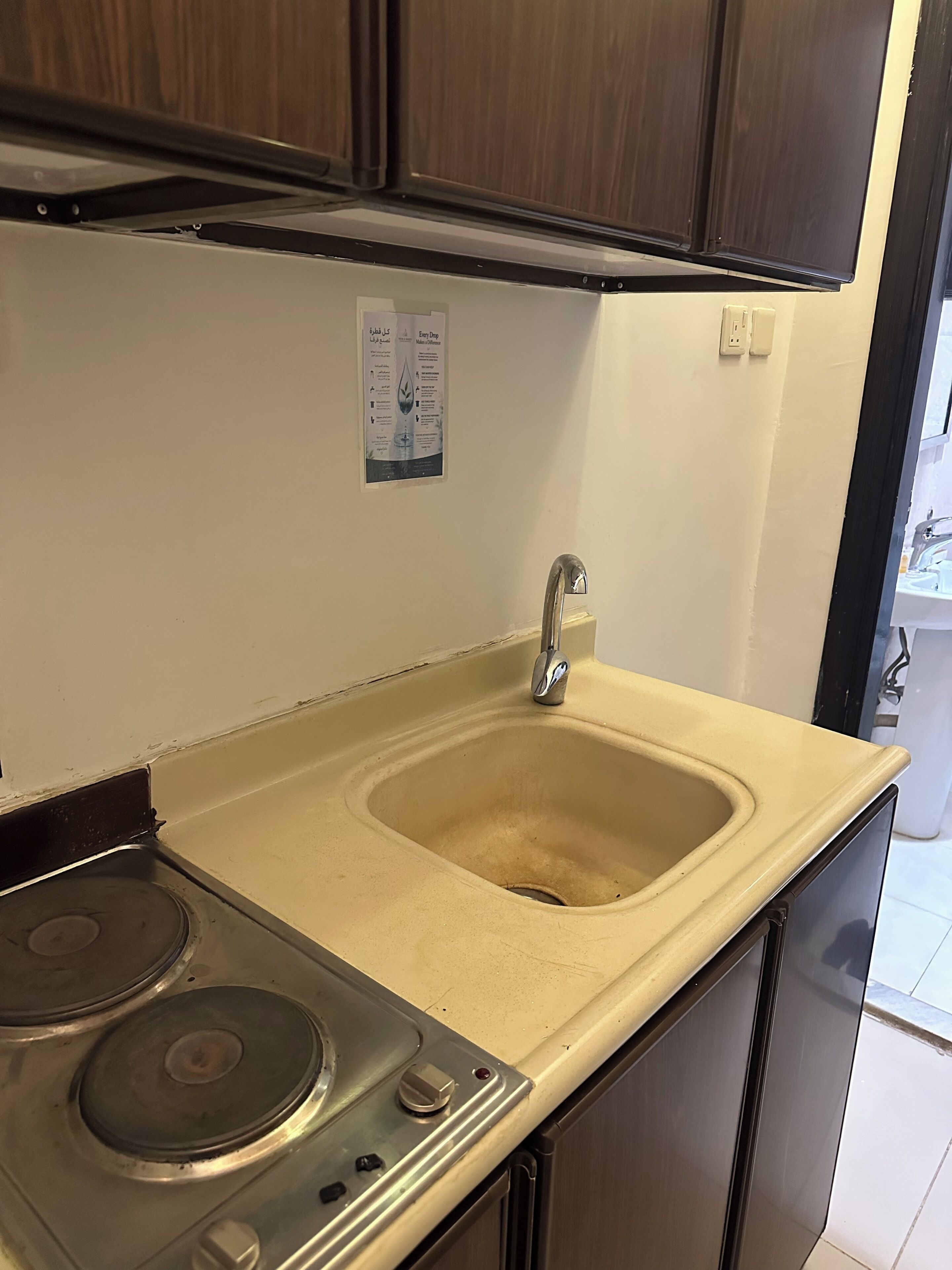 Een keuken met een spoelbak, fornuis en kasten.