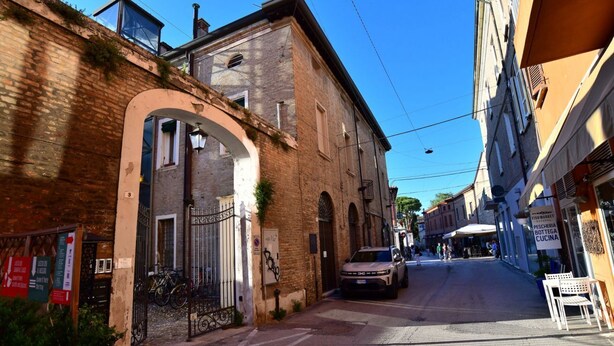 A narrow street with buildings on either side, a parked car, and a bicycle. - Charming 38 sqm studio, for 3 people, located on the 2nd floor (attic) of a renovated period building from the 16th century (access only permitted via lift).The property is located in the heart of the historic center of Ravenna (in the restricted traffic (Ravenna)