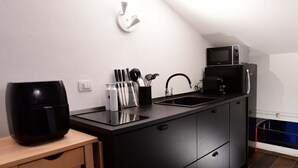 A compact kitchen with a microwave, coffee maker, and knife set on the counter. - Charming 38 sqm studio, for 3 people, located on the 2nd floor (attic) of a renovated period building from the 16th century (access only permitted via lift).The property is located in the heart of the historic center of Ravenna (in the restricted traffic (Ravenna)