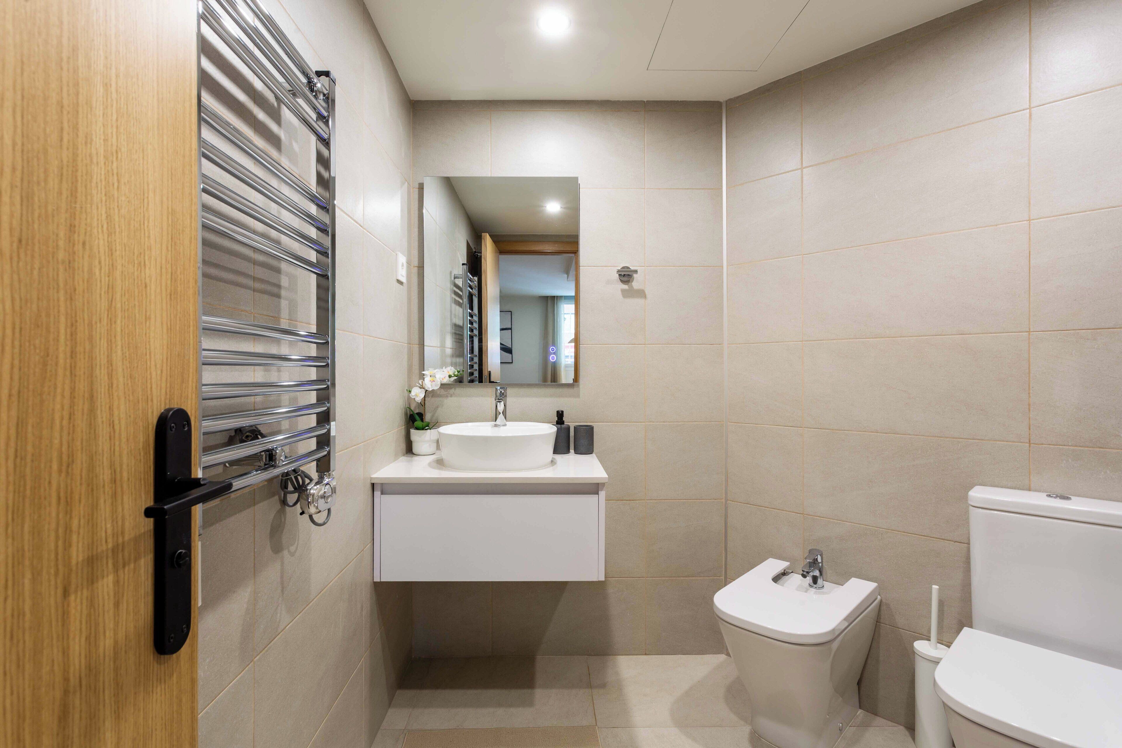 Ein Badezimmer mit Toilette, Waschbecken und Spiegel.