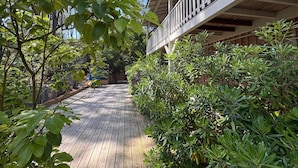 Une terrasse en bois menant à un bâtiment doté d’un balcon.