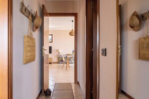 Ein Flur mit einer Holztür, einem gewebten Korb und einer gewebten Tasche an der Wand.
