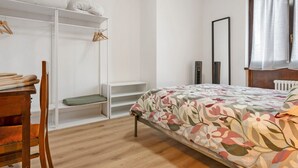 Une chambre à coucher avec un lit, une armoire, une chaise et un radiateur.