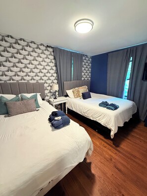 Ein Hotelzimmer mit zwei Betten, einem Nachttisch und einer Wand mit Muster.