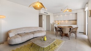 Ein modernes Wohnzimmer mit einer Couch, einem Couchtisch und einem Essbereich mit Stühlen.