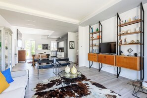 A modern living room with a glass coffee table, a cowhide rug, and a TV on a wooden cabinet. - Stunning private villa for 6 people with WIFI, A/C and veranda (Fano)