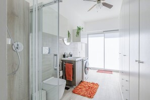 A modern bathroom with a glass shower enclosure, a toilet, a sink, and a washing machine. - Stunning private villa for 6 people with WIFI, A/C and veranda (Fano)