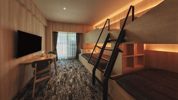 Habitación compacta con literas, un televisor de pantalla plana, una mesita con sillas y una ventana con cortinas.