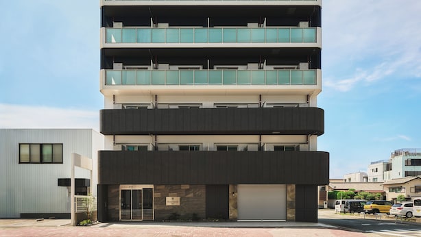 Un edificio de varios pisos con techo plano, ventanas amplias y una puerta de garaje.