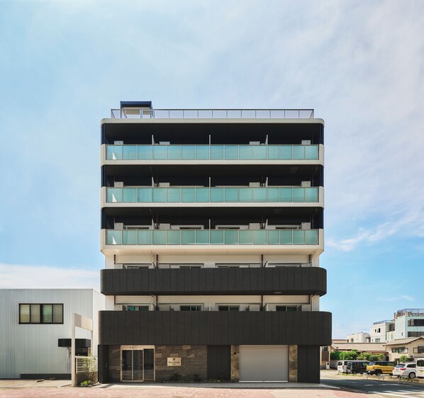 A multi-story building with a flat roof, large windows, and a garage door. - Moat Inside Hakata (Fukuokasi Hakataku)