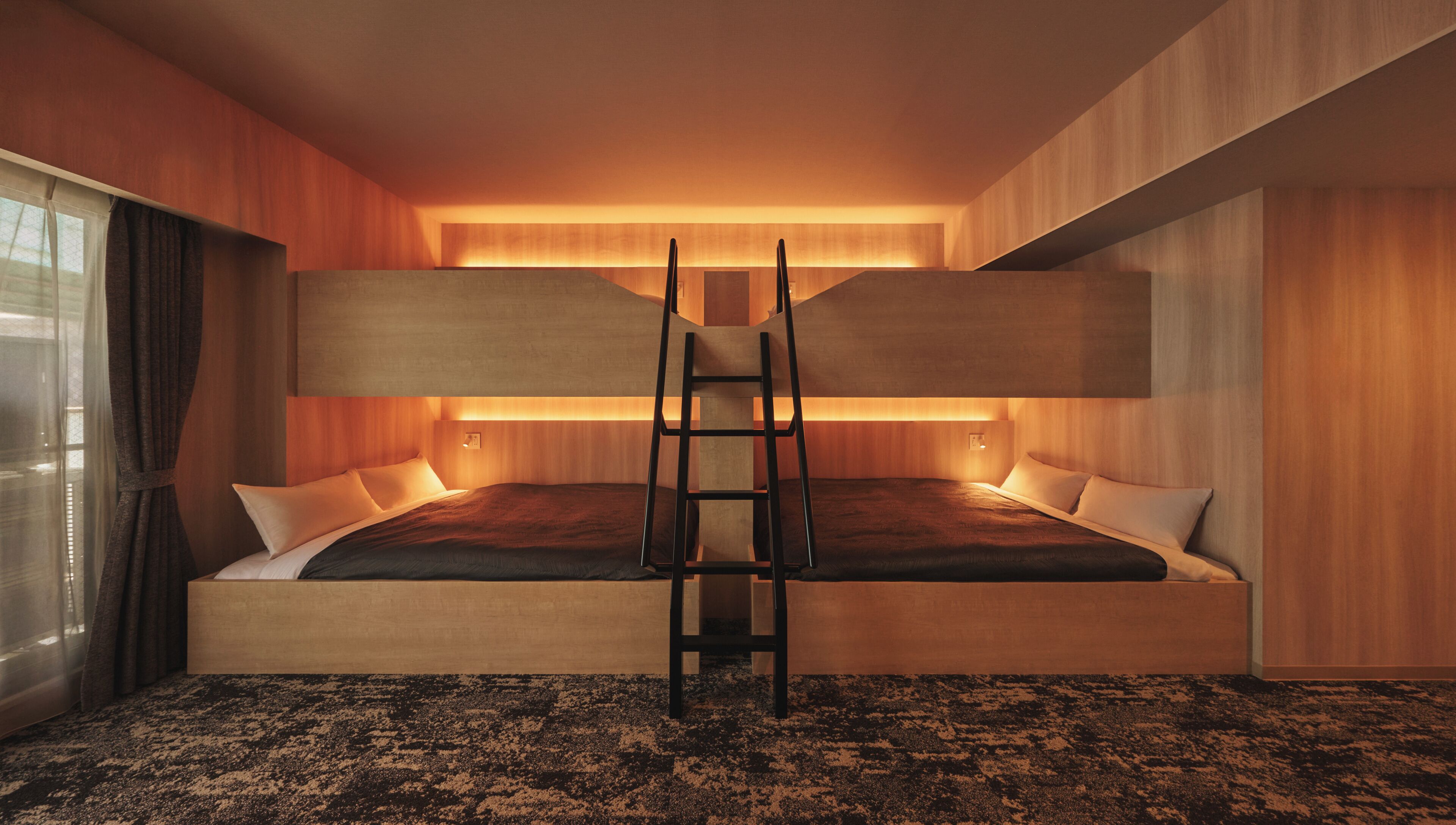 A bunk bed with a ladder in the middle, wooden walls, and a carpeted floor.