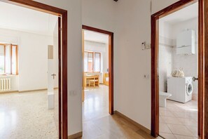 Quarto com porta de madeira, máquina de lavar e radiador.