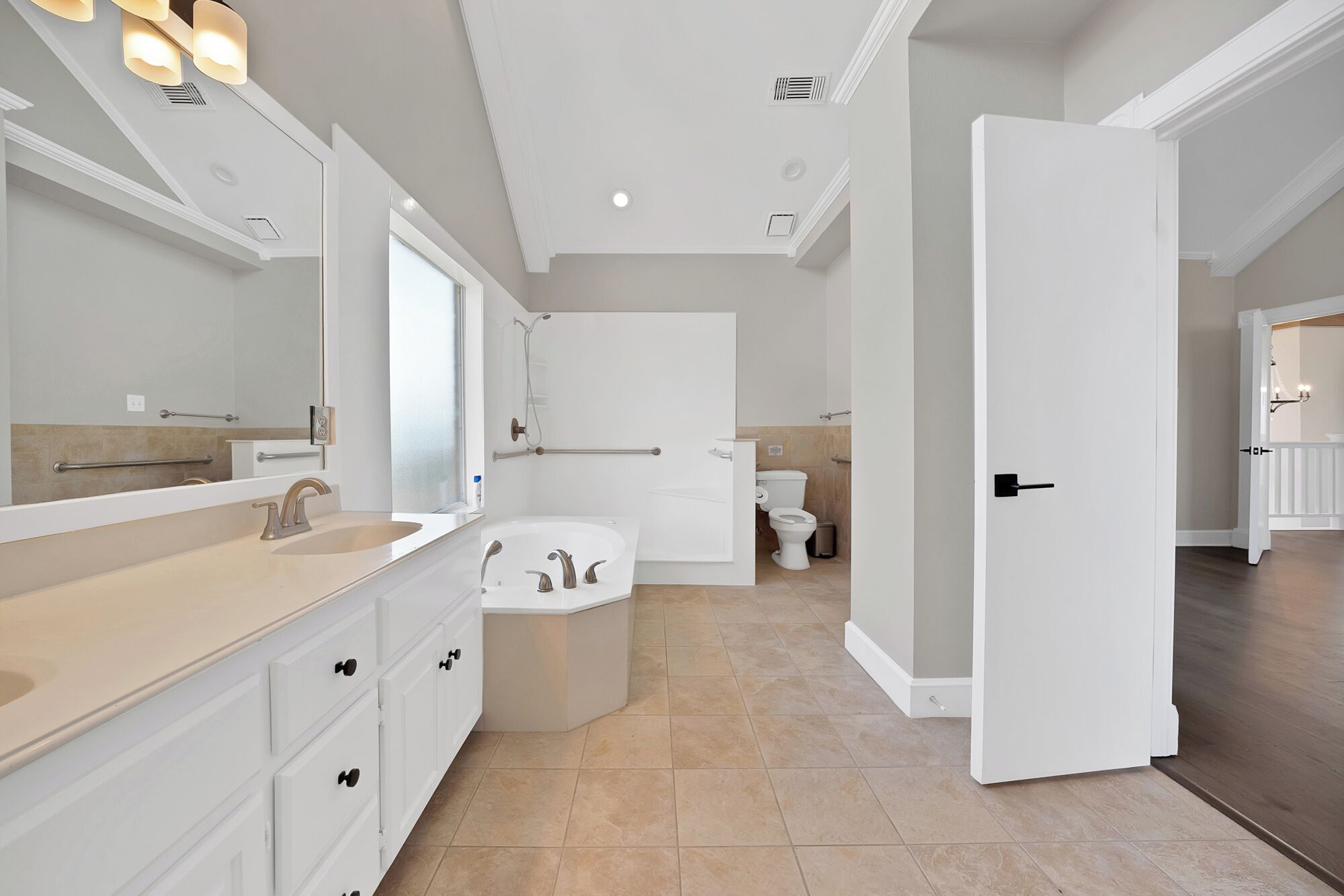 Een moderne badkamer met bad, toilet en wastafel.