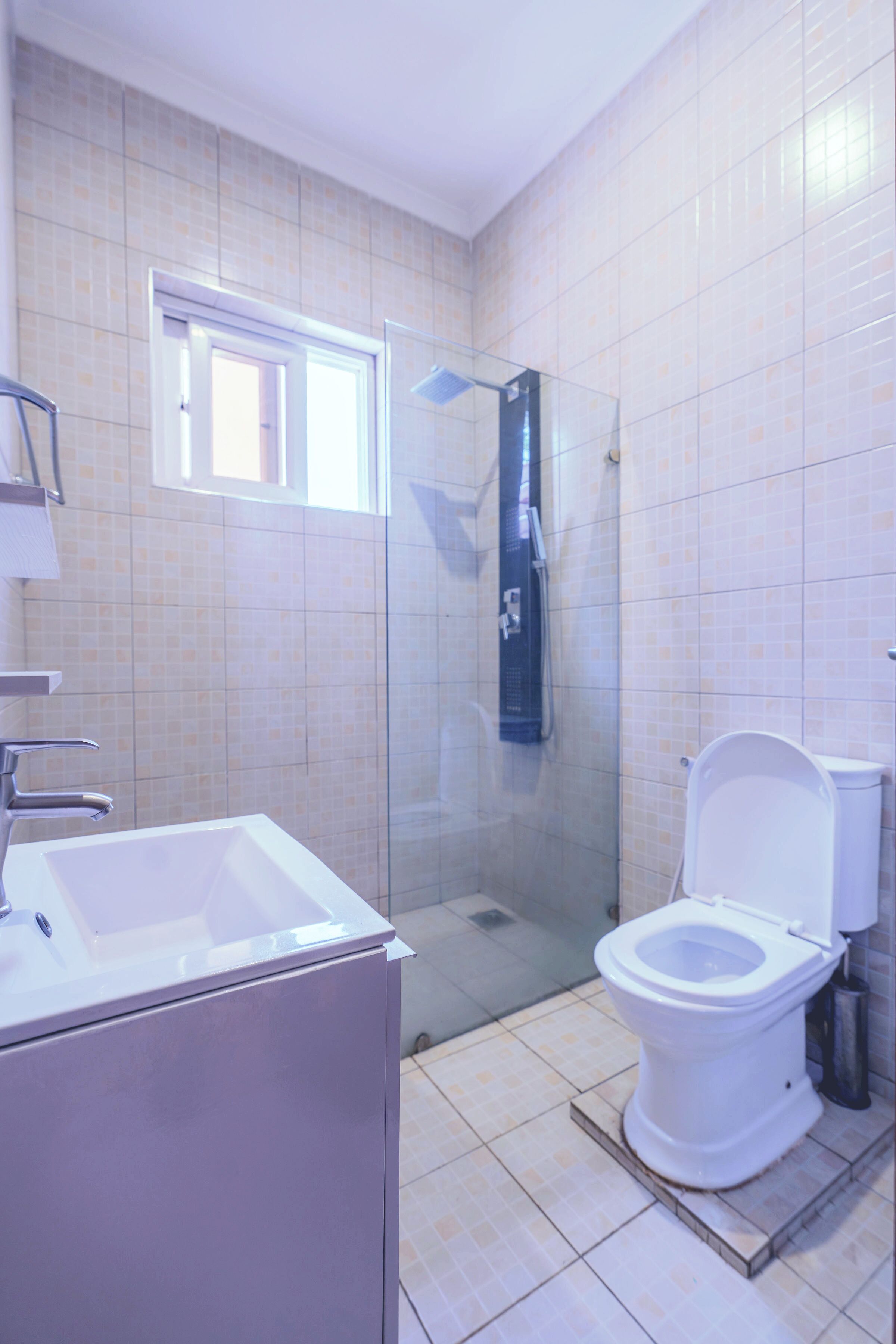 A bathroom with a shower, toilet, and sink.