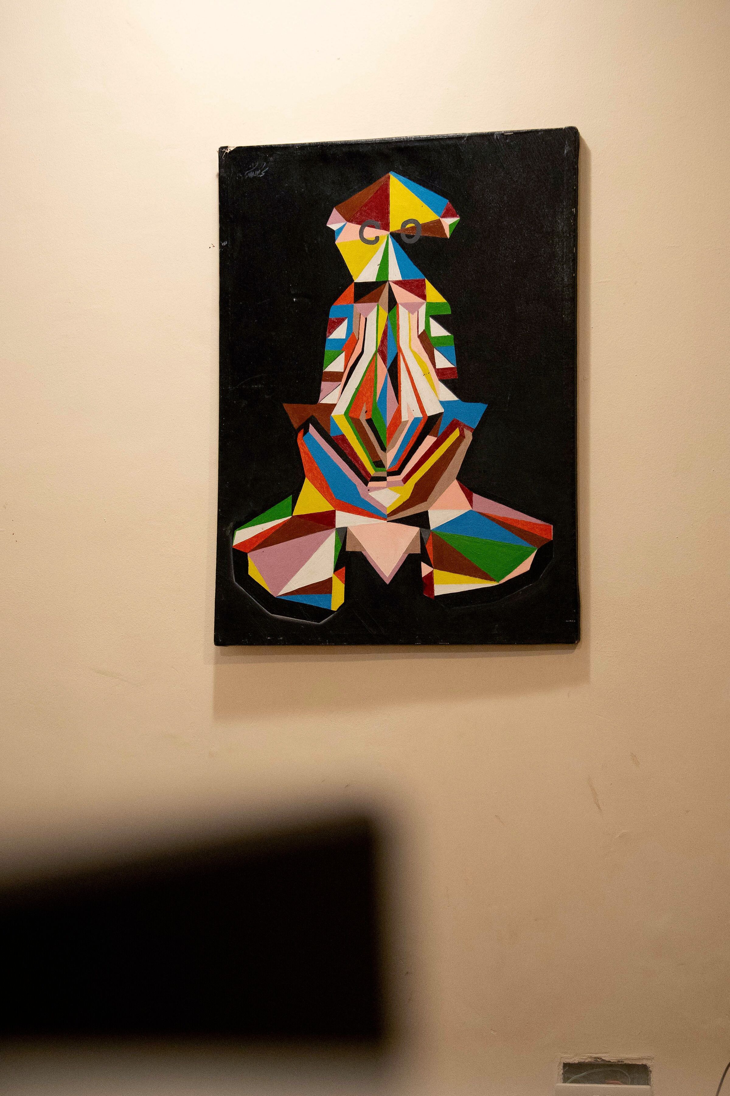 Pintura abstrata geométrica sobre tela preta.