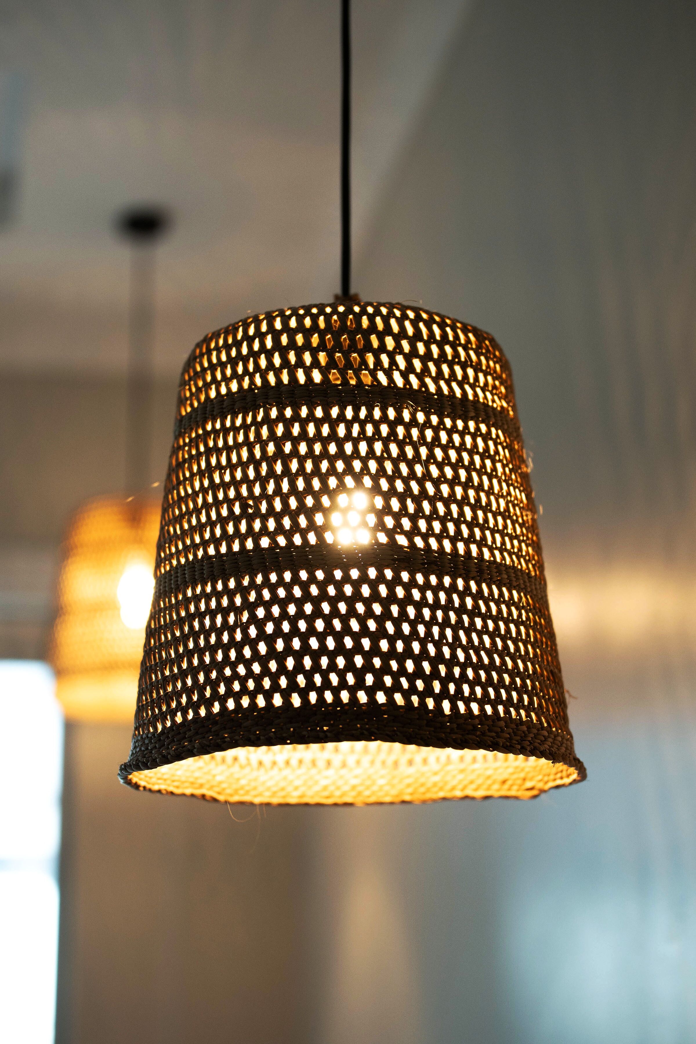 A hanging lamp with a perforated metal shade.