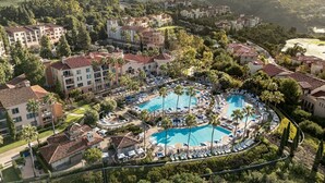 A resort with multiple swimming pools, palm trees, and a mountainous backdrop. - 2-bedroom condo at the incredible Marriott Newport Coast Villas Resort (Newport Beach)