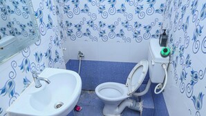 A bathroom with a sink, toilet, and bidet, tiled with blue and white patterns. - Silver Residency (Bhubaneshwar)