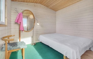 A room with a bed, a chair, a mirror, and a floor lamp. - Family house with beach access at Bildsø Strand (Slagelse)